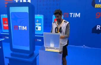 Alberto Cowboy durante a 9ª Prova do Líder do BBB 26, inserindo o celular no totem ao lado de totens da TIM