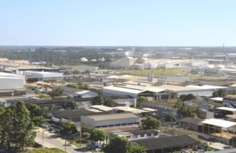 Vista aérea de polo industrial na Serra onde atua a indústria do plástico Serra ES, com fábricas e tanques de armazenamento.