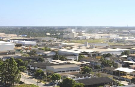 Vista aérea de polo industrial na Serra onde atua a indústria do plástico Serra ES, com fábricas e tanques de armazenamento.