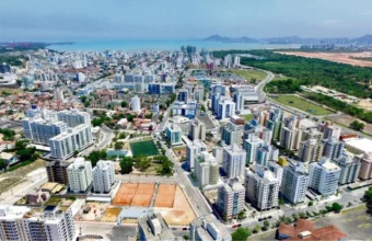 Vista aérea de Jardim Camburi em Vitória mostrando prédios residenciais, área verde do Parque Botânico da Vale e o mar ao fundo
