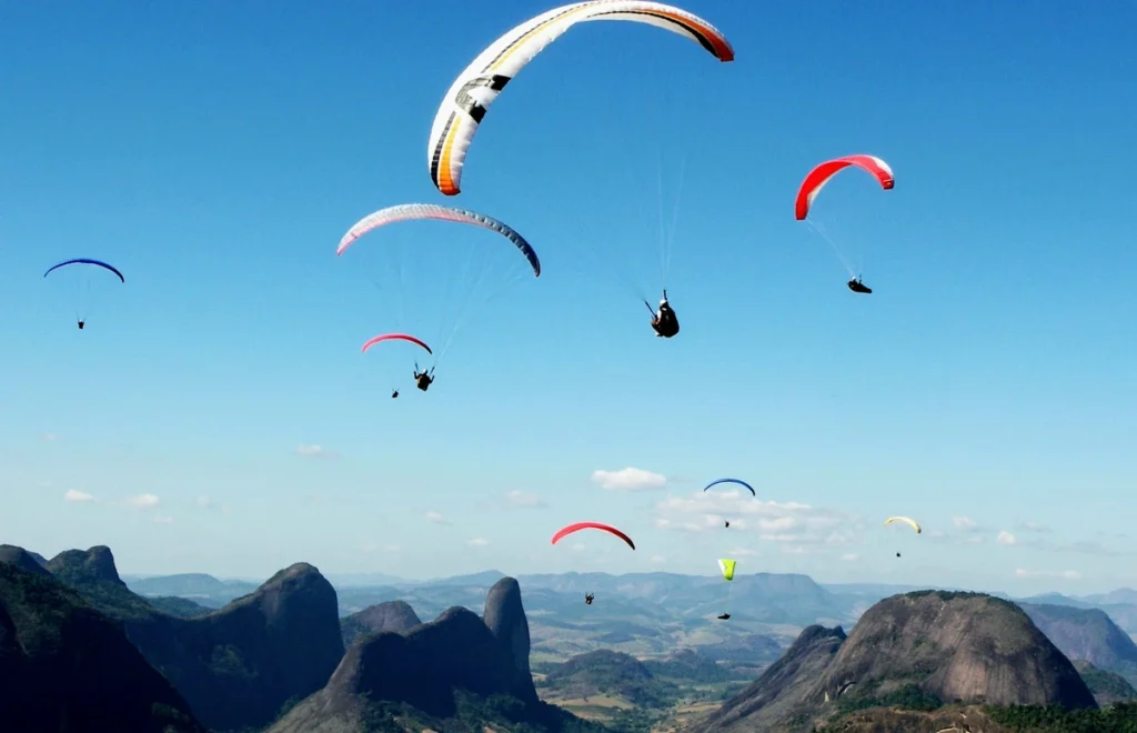 Parapentes sobrevoando as formações rochosas de Pancas durante o Campeonato Capixaba de Voo Livre no Espírito Santo — capital capixaba dos esportes radicais