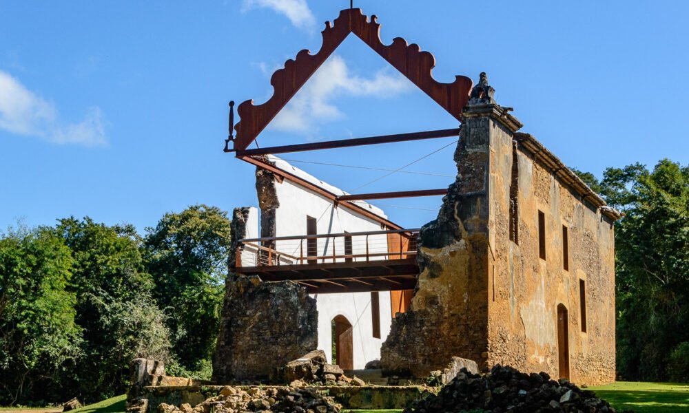 Ruínas de pedra com estrutura metálica e passarela de visitação no Sítio Histórico de Queimado, na Serra.