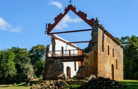 Ruínas de pedra com estrutura metálica e passarela de visitação no Sítio Histórico de Queimado, na Serra.