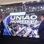 TSE aprova federação União Progressista: qual o impacto nas eleições de 2026 Políticos assistem ao anúncio da federação União Progressista em grande telão na Câmara dos Deputados.